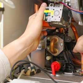 Technician servicing or Repair of a gas boiler, setting up and servicing. gas boiler for heating